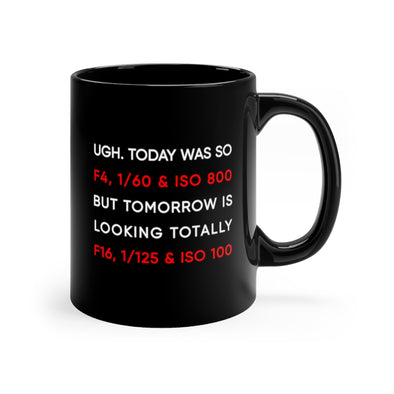 Black, 11 ounce, ceramic mug with the words "Ugh. Today was so f4, 1/60 ISO 800, but tomorrow is looking totaly f16, 1/125 ISO 100" in white and red.