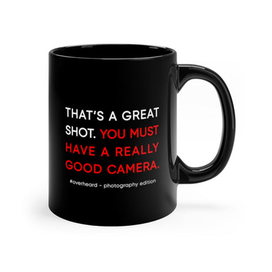 Black, 11 ounce, ceramic mug with the words "That's a great shot. You must have a really good camera." in white and red.