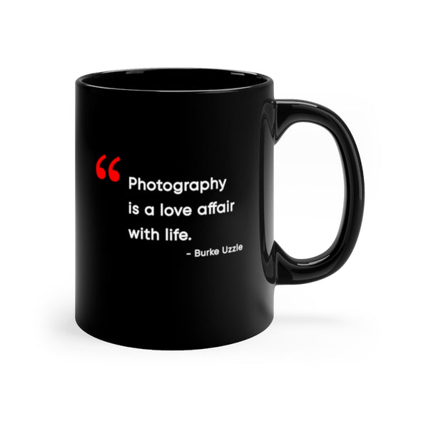 Black, 11 ounce, ceramic mug with the words "Photography is a love affair with life" in white and red. Quote is by Burke Uzzle.