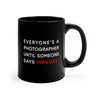 Black, 11 ounce, ceramic mug with the words Everyone's a photographer until someone says manual, in white and red.